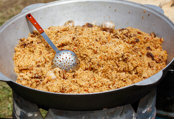 Uzbek pilaf cooked in a cauldron over a fire