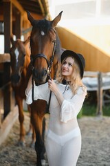 Obraz premium Beautiful model girl stands in a long dress with a horse