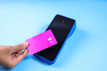 Customer hand tapping credit card to touchscreen POS terminal with NFC or contactless technology. Card and screen mockup.