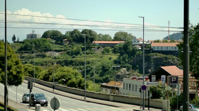 Static shot of some greenery area and a road in Porto, Portugal.