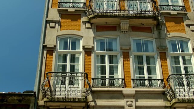 Tilting down over a building in Porto, with yellow tiles on the fasade.