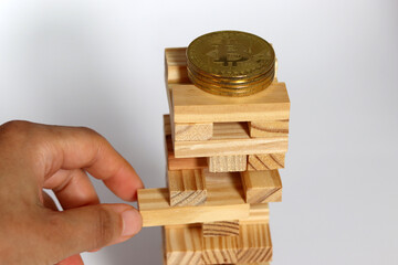 Bitcoin and Cryptocurrency Investment Risk. Bitcoins are placed on wooden blocks and one of the...
