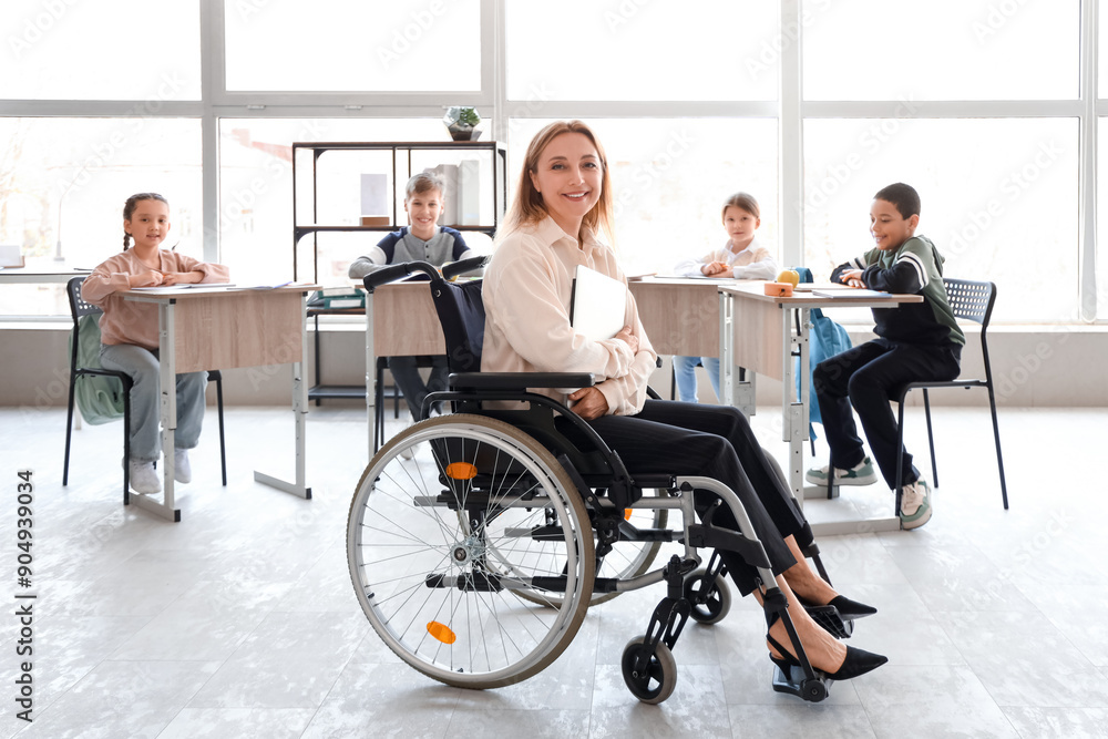 Wall mural Mature teacher in wheelchair with laptop conducting lesson at school