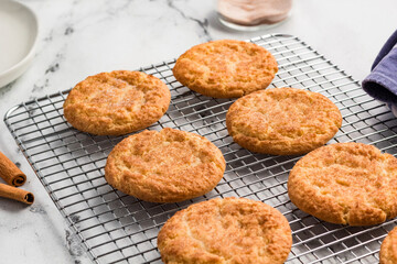 Freshly baked snickerdoodle cookies cooling on a wire rack