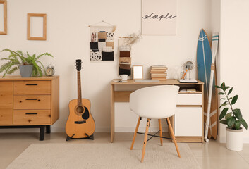 Interior of teenager's room with workplace, organizers and surfboard