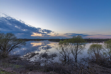 A calm lake with a beautiful sunset in the background