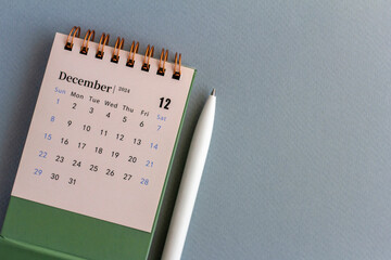 Calendar for December 2024 on a grey background.