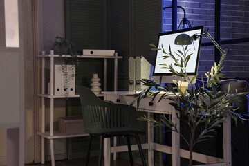 Workplace with computer, folders and glowing lamp in dark office