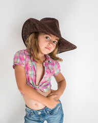 Little girl in cowboy hat and jeans isolated on white background.