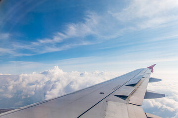 Obraz premium View from the airplane window at a beautiful cloudy sky and the airplane wing