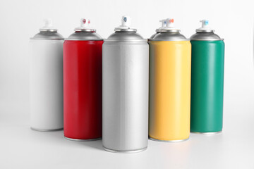 Cans of spray paint on white background