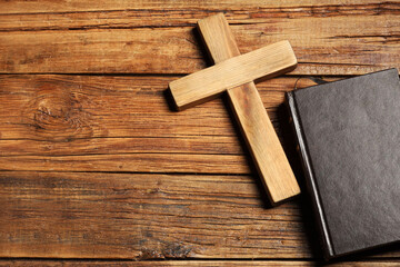 Bible and cross on wooden table, flat lay with space for text. Religion of Christianity