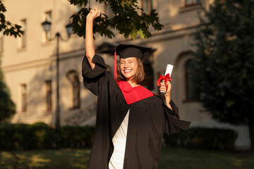 Happy female graduating student with diploma outdoors