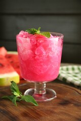 Tasty watermelon sorbet in glass dessert bowl and mint on table, closeup