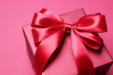 Gift box with bow on pink background