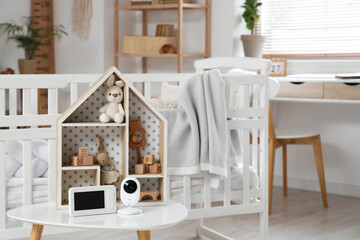 Baby monitor with toys on table in children's bedroom, closeup
