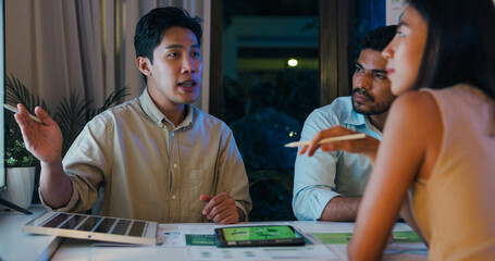 Group diverse Asia businesspeople talk ESG strategies risk management solar panel workshop night, SDGs, global warming, green finance and investment and net zero waste in boardroom training building.