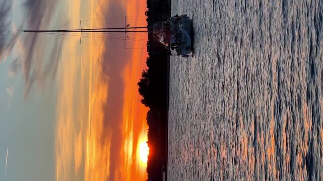 Yachts moored on buoys near the shore in the bay of Uvala Gradina near the town of Vela Luka on the island of Korcula at sunset lights in Croatia