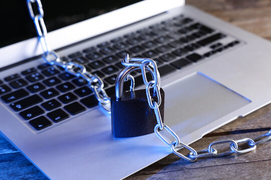 Padlock with chain on laptop, closeup. Cyber security concept