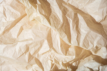 Crumpled beige paper texture with folds and creases.