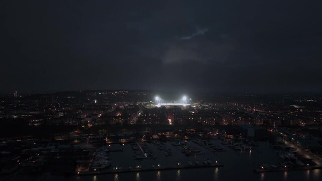 Aerial night view of Aalborg, Denmark. Illuminated city stadium in the background