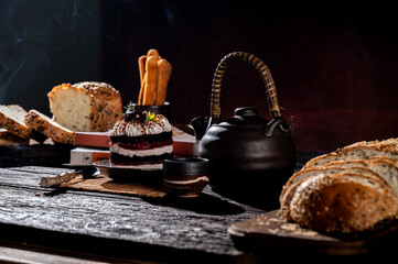 A delicious chocolate nut cake on a white plate surrounded by various pastries and a cup of coffee, perfect for breakfast or dessert
