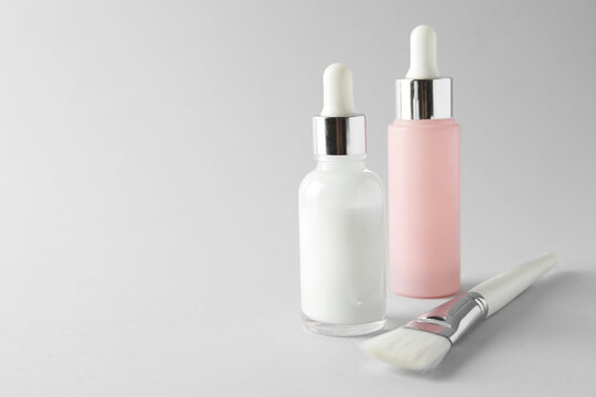 Bottles of chemical peel and brush on light background, space for text. Peeling procedure