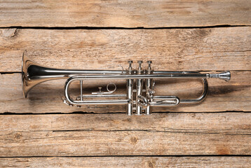 One trumpet on wooden table, top view