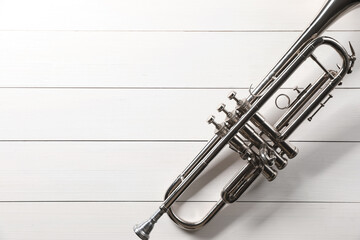 One trumpet on white wooden table, top view. Space for text
