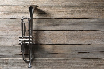 Fototapeta premium Trumpet on wooden table, top view. Space for text