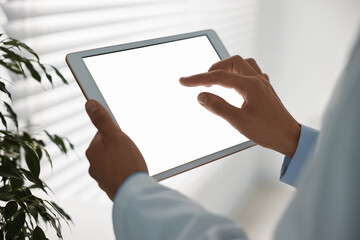 Doctor using tablet in hospital, closeup view
