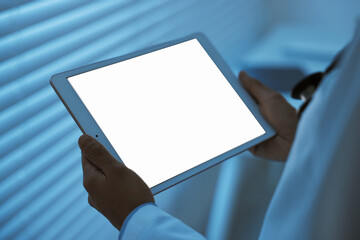 Doctor using tablet in hospital at night, closeup