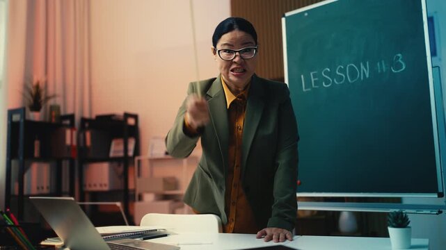 Comically angry Asian woman teacher shouting at students during lesson, humor