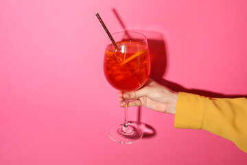 Woman with glass of refreshing cocktail on pink background, closeup. Space for text
