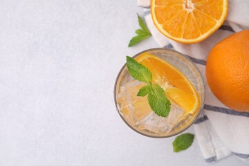 Refreshing water with orange and mint in glass on light table, flat lay. Space for text