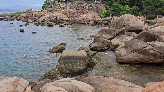 4k pan tilt a Hon Chong cape rock garden by the sea. Tourists travel walking on huge coastal boulders in Hon Chong rock garden in Nha Trang city, Vietnam.
