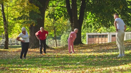 Active Seniors Exercising in the Park Guided by a Young Instructor. Concept of Lifestyle, Fitness, Workout, Flexibility, Training, Healthy Aging, Activity, Health, Coaching, Agility, Longevity