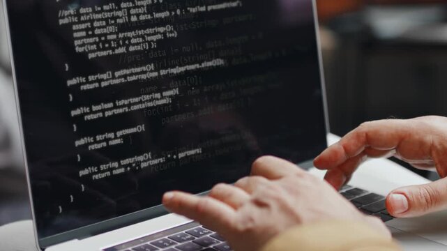 A programmer writes code on a computer
