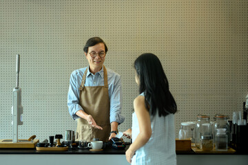 Young woman customer paying with a credit card in coffee shop. Cashless technology concept