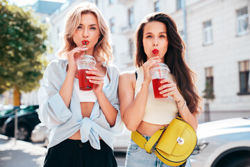 Two young beautiful smiling glam female in trendy summer clothes. Sexy women posing outdoors....