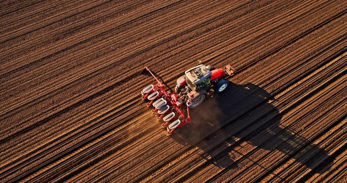 An aerial shot of a farmer in tractor seeding soybean crops