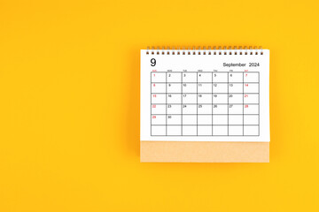 September 2024 desk calendar on yellow color background, position with copy space.