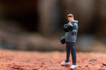 Miniature people, A man lifting dumbbells is set against a textured background