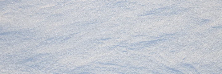 Beautiful winter background with snowy ground. Natural snow texture. Wind sculpted patterns on snow surface. Wide panoramic texture for background and design. © Andrei Stepanov