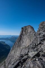 High steep rock walls on the Stetinden peak in North Norway with hikers and climbers trying to reach the summit