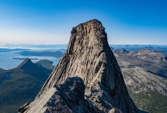 High steep rock walls on the Stetinden peak in North Norway with hikers and climbers trying to reach the summit