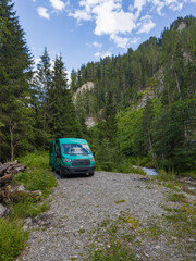 Van freistehend am Ufer eines Flusses in den Alpen