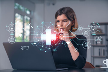 Woman working on laptop with medical icons overlay in office.
