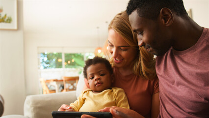 Obraz premium Family Enjoying Quality Time Together While Watching a Tablet in Their Cozy Living Room