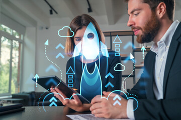 Business professionals discussing a startup project with a digital rocket hologram.